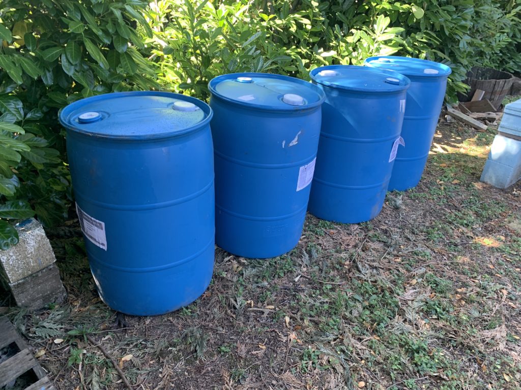 Four blue plastic barrels